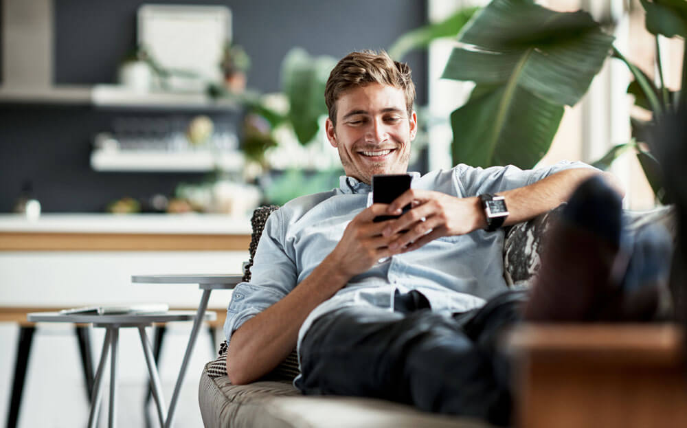 Man smilling and looking at his cell phone