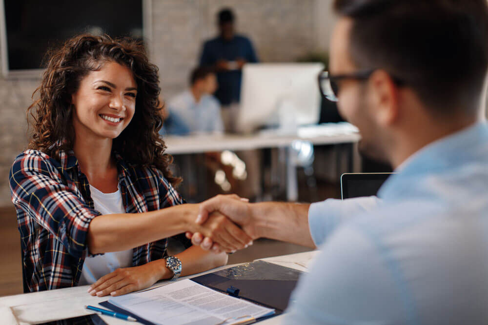 girl and boy shaking hands at table